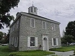 A two-story, federal-style grey brick building